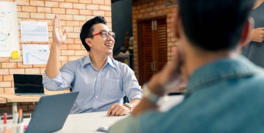 Bir grup iş arkadaşı gayri resmi bir toplantı yapıyor, iş adamları ofiste fikirleri tartışıyor.