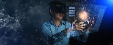 Genç Asyalı teknisyen sanal gerçeklik elinden büyüye dokunarak çalışıyor. Sanal gerçeklik eline dokunuyor. Ampul ve cihaz ekranı yaratıcı fikirler kavramına dokunuyor.