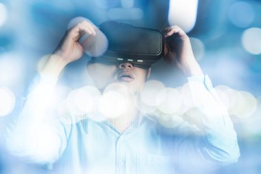 Genç Asyalı subay siyah Hololens gözlükleri ile sanal gerçekliğin el ve el değme efektini kullanıyor.