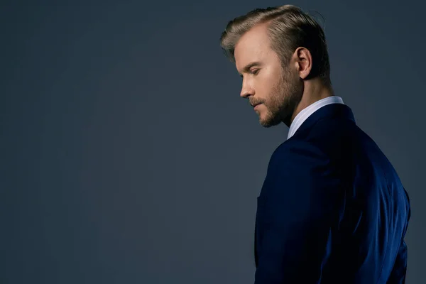 Zarif, beyaz, başarılı, sakallı bir iş adamı. Resmi takım elbise, gri arka plan.