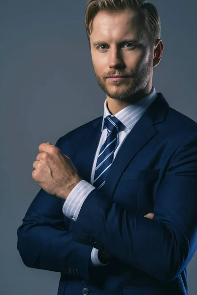 Zarif, beyaz, başarılı, sakallı bir iş adamı. Resmi takım elbise, gri arka plan.