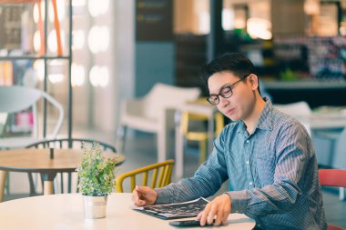 Asyalı iş adamı şirket girişimcisi yeni mağaza ofis arka plan fikirlerinde mutlulukla gülümsüyor.
