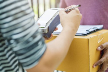 Teslimat fikirleri konsepti. Hindistan kurye paket ürününü müşteriye mutluluk ve neşe dolu ev kapısı girişi ile kapatın.