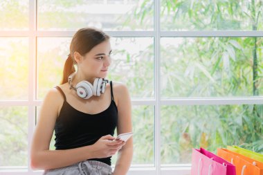 Güzel beyaz kadın tatil kulaklıklarıyla rahatla mutluluk ve neşe dolu müzikler dinle.