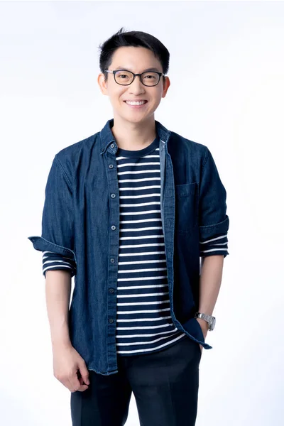akıllı çekici Asyalı gözlüklü erkek ayakta duruyor ve gülümsüyor ferahlık ve neşe dolu mavi gömlek portresi beyaz arka plan