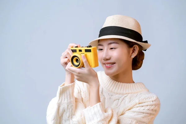魅力的な美しいアジアの女性のカジュアルドレスは帽子手を着用フィルムカメラ旅行休暇のコンセプト白の背景 — ストック写真
