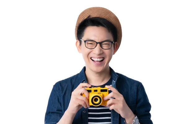 旅行衣装コンセプトアジアの魅力的な男性の眼鏡笑顔幸せと喜びの手は黄色のレトロフィルムカメラ休暇時間白の背景を保持 — ストック写真