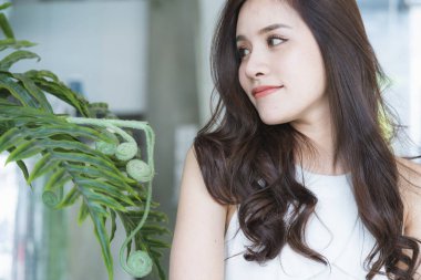 Güzel Asyalı kadın güzel gülümseme ve yeşil lealı sağlıklı cilt