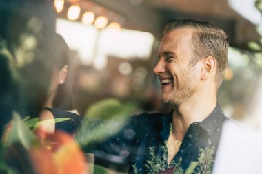 Çok uluslu bir grup arkadaş, eğlence ve mutlulukla sohbetin keyfini çıkarırlar. Kafe restoranının arka planında gelişigüzel fikirler buluşur.