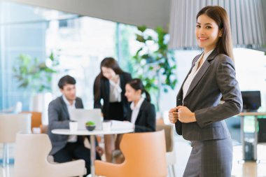 Portre yakın çekim akıllı çekici Asyalı iş kadını gülümsemesi özgüvenli ve modern ofis arka planında liderlik