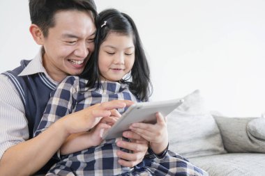 Annesiyle mutlu bir Asyalı hafta sonu tatili. Babası ve kızı bir arada kalsın. Tablet ve dizüstü bilgisayar kullan.