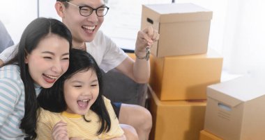 Mutlu Asyalı aile babası anne kız yeni evin tadını çıkar ve neşeli kahverengi eşyalar kutusuyla birlikte paketleri boşalt fikirleri eve götür iç mimari kavramları