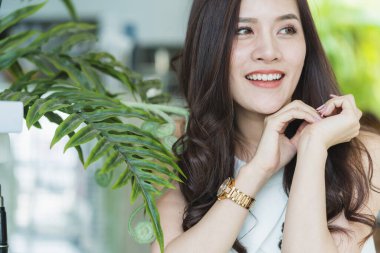 Güzel Asyalı kadın güzel gülümseme ve yeşil lealı sağlıklı cilt