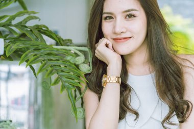 Güzel Asyalı kadın güzel gülümseme ve yeşil lealı sağlıklı cilt