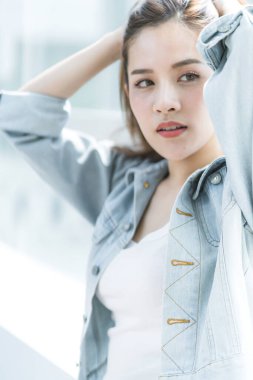 Kahverengi uzun saçlı Asyalı güzel kadın beyaz kostüm