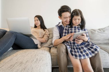 Annesiyle mutlu bir Asyalı hafta sonu tatili. Babası ve kızı bir arada kalsın. Tablet ve dizüstü bilgisayar kullan.