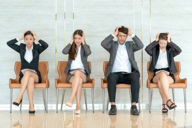 Asyalı iş adamlarından oluşan bir grup aday, iş görüşmesi için sırada bekliyor, el ele tutuşuyorlar.