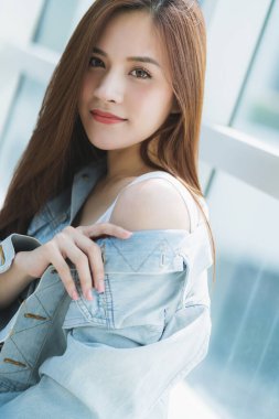 Kahverengi uzun saçlı Asyalı güzel kadın beyaz kostüm