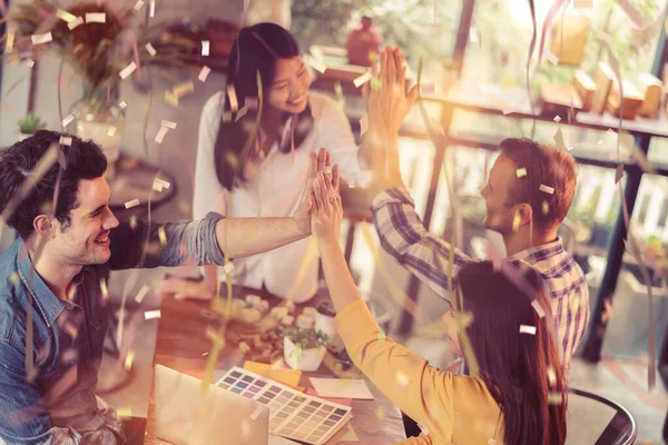 Kafkas ve Asyalı iş arkadaşlarıyla yaratıcı iş toplantısı kağıt dizüstü bilgisayar ve mutluluk ve neşe dolu kafe geçmişi ile tartışıldı
