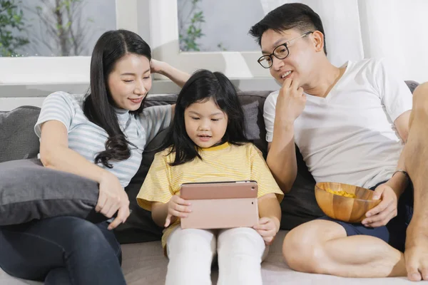 快乐的亚洲家庭爸爸 妈妈和女儿坐在一起放松地玩着平板电脑回家甜蜜的家的概念 — 图库照片