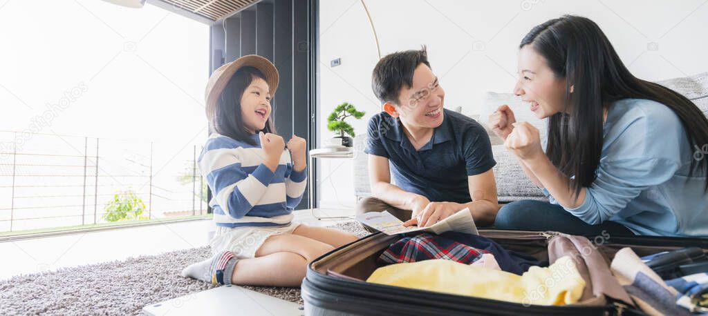 Asian Family travel concept happiness dad mom daughter packing stuff  cloths and planing for vacation road trip with exited and joyful