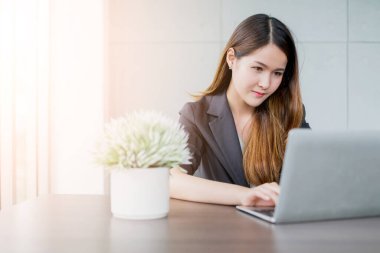 çekici zeki ve güzel iş kadını Asyalı pozitif düşünce ve ofis arka planında dizüstü bilgisayarla çalış