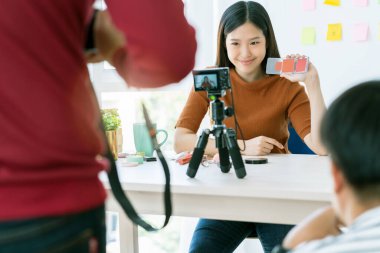 Güzel Asyalı uzun saçlı kadın makyaj adımlarını sosyal medyada mutluluk ve neşe içinde yaşadığını gösteriyor.