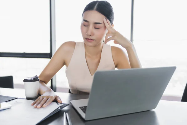 sick asian office woman bad health with office syndrome while working with laptop in office