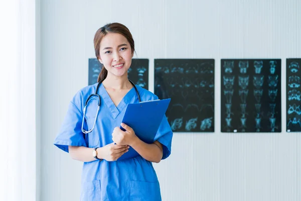 自信のあるクリニック病院の背景で手術と笑顔の準備ができているスマートで魅力的なアジア女性医師 — ストック写真