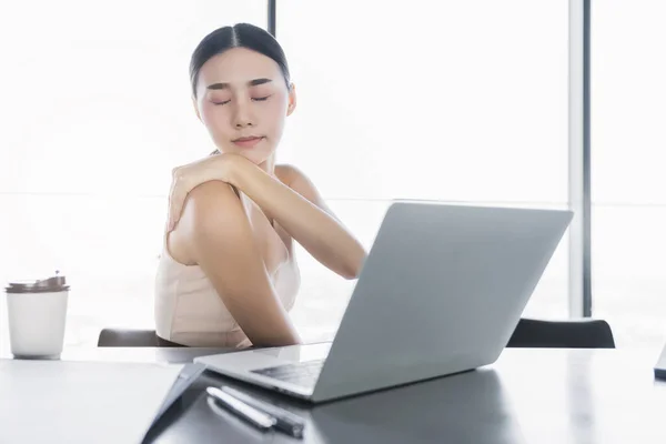 sick asian office woman bad health with office syndrome while working with laptop in office