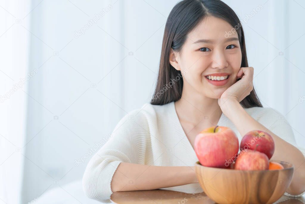 healthy eating concept beautiful asian woman smile hand show fresh apple in wooden bowl with happiness and joyful white room background