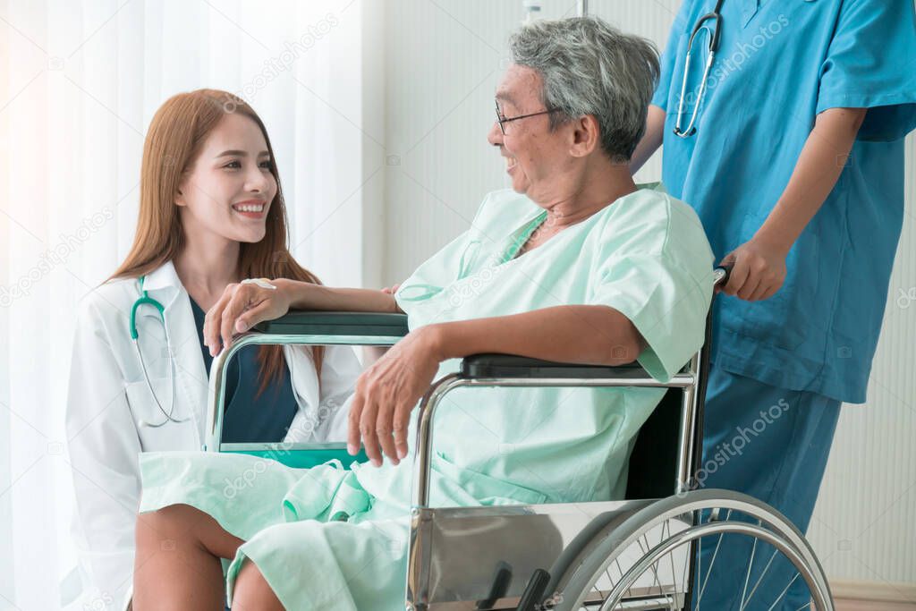 asian attractive woman doctor and nurse takecare old senior patient disabled on wheelchair in hospital health and support ideas concept