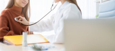 Asyalı kadın doktor göğüs kanseri semptomları, risk faktörleri ve klinik ofis afişi altında hasta kontrolü