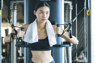 Güzel Asyalı spor kadını spor makinesiyle spor yaparken spor yaparken spor konsepti vücut geliştirici sağlıklı yaşam stili eğitimi alırken güzel kadın halterini kaldırıyor.