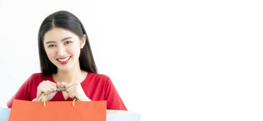 Çekici, güzel Asyalı kadın, kırmızı elbise, alışveriş çantası, büyük gülümseme, mutluluk ve neşeli beyaz arka plan.