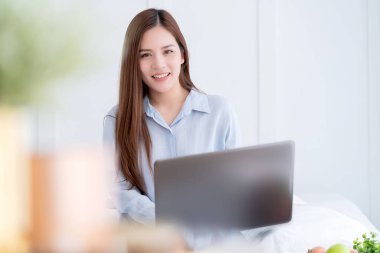 Güzel, çekici, kaotik bir kadın elbisesi ev fikirleri konseptinde dizüstü bilgisayarla çalışıyor.