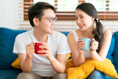 Mutlu Asyalı çift evleniyor. Sabahın keyfini çıkarın. Kanepede aşk ve akrabayla birlikte.