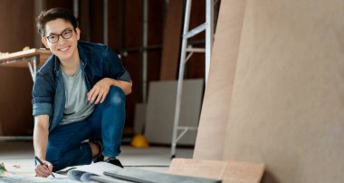 akıllı çekici gözlük Asyalı erkek zanaatkar ya da iç mimar sitenin konstrüksiyon ev dekorasyonu ve geliştirme konseptinde çalışan odaklı ahşap.