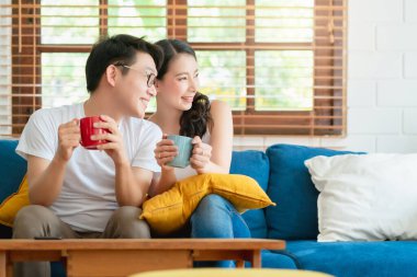 Mutlu Asyalı çift evleniyor. Sabahın keyfini çıkarın. Kanepede aşk ve akrabayla birlikte.