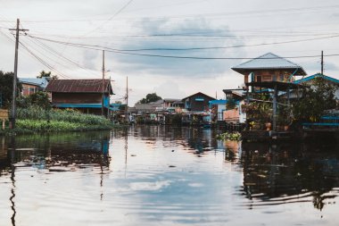 Bangkok, Tayland 'da gün batımında nehir kıyısındaki ahşap evler
