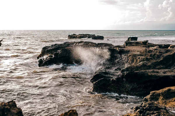 Gün batımında kayalık oluşum uçurumlarına düşen dalgalar güzel bir ışıkla
