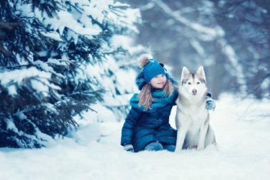 Kışın ormanda Sibirya Husky 'si olan küçük kız.