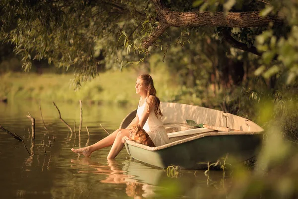 Gölde küçük bir köpekle küçük bir kız. Işığın altında.