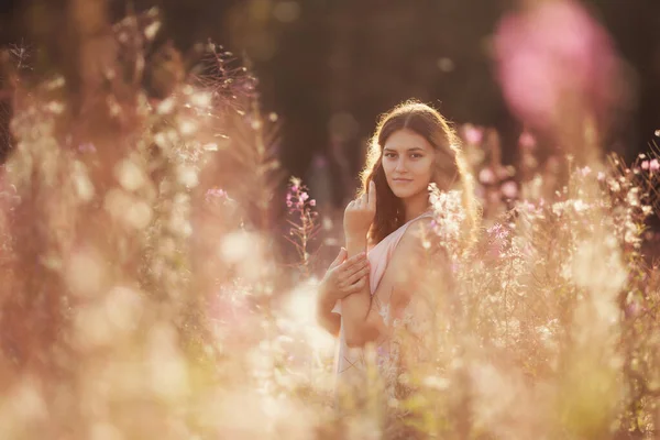 Gün batımında çiçek tarlasında güzel bir genç kız