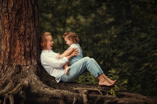 Anne ve kızı ormandaki ağaçta oturuyorlar.