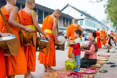 Luang Prabang, Laos - Mar 05 2015: sadaka sabah toplama Budist rahipler. Rahipler de Luang Prabang için sadaka verme geleneği turistlere genişletilmiş.