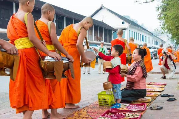 Luang Prabang, Laos - 05 de março de 2015: monges budistas coletando esmolas pela manhã. A tradição de dar esmolas aos monges em Luang Prabang foi estendida aos turistas. . — Fotografia de Stock