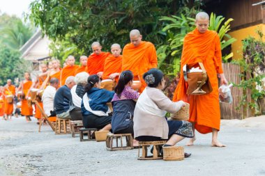 Luang Prabang, Laos - Mar 06 2015: sadaka sabah toplama Budist rahipler. Rahipler de Luang Prabang için sadaka verme geleneği turistlere genişletilmiş.