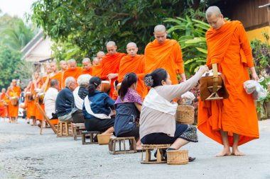 Luang Prabang, Laos - Mar 06 2015: sadaka sabah toplama Budist rahipler. Rahipler de Luang Prabang için sadaka verme geleneği turistlere genişletilmiş.