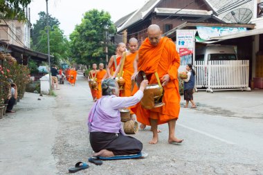 Luang Prabang, Laos - Mar 06 2015: sadaka sabah toplama Budist rahipler. Rahipler de Luang Prabang için sadaka verme geleneği turistlere genişletilmiş.